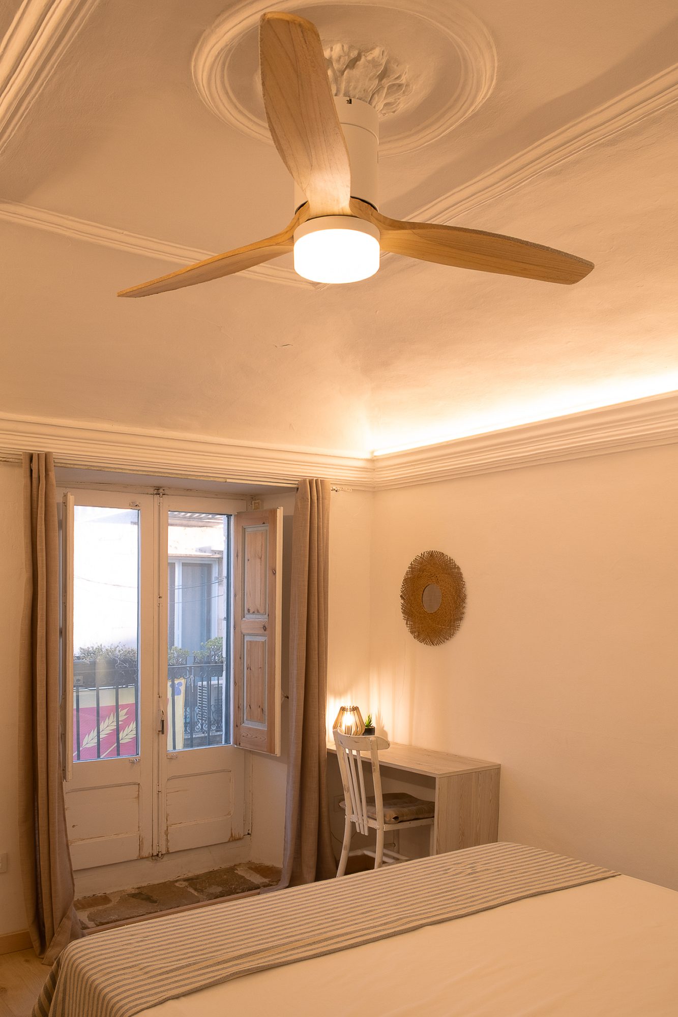 Habitació 3 — ventilador de sostre i balcó al carrer