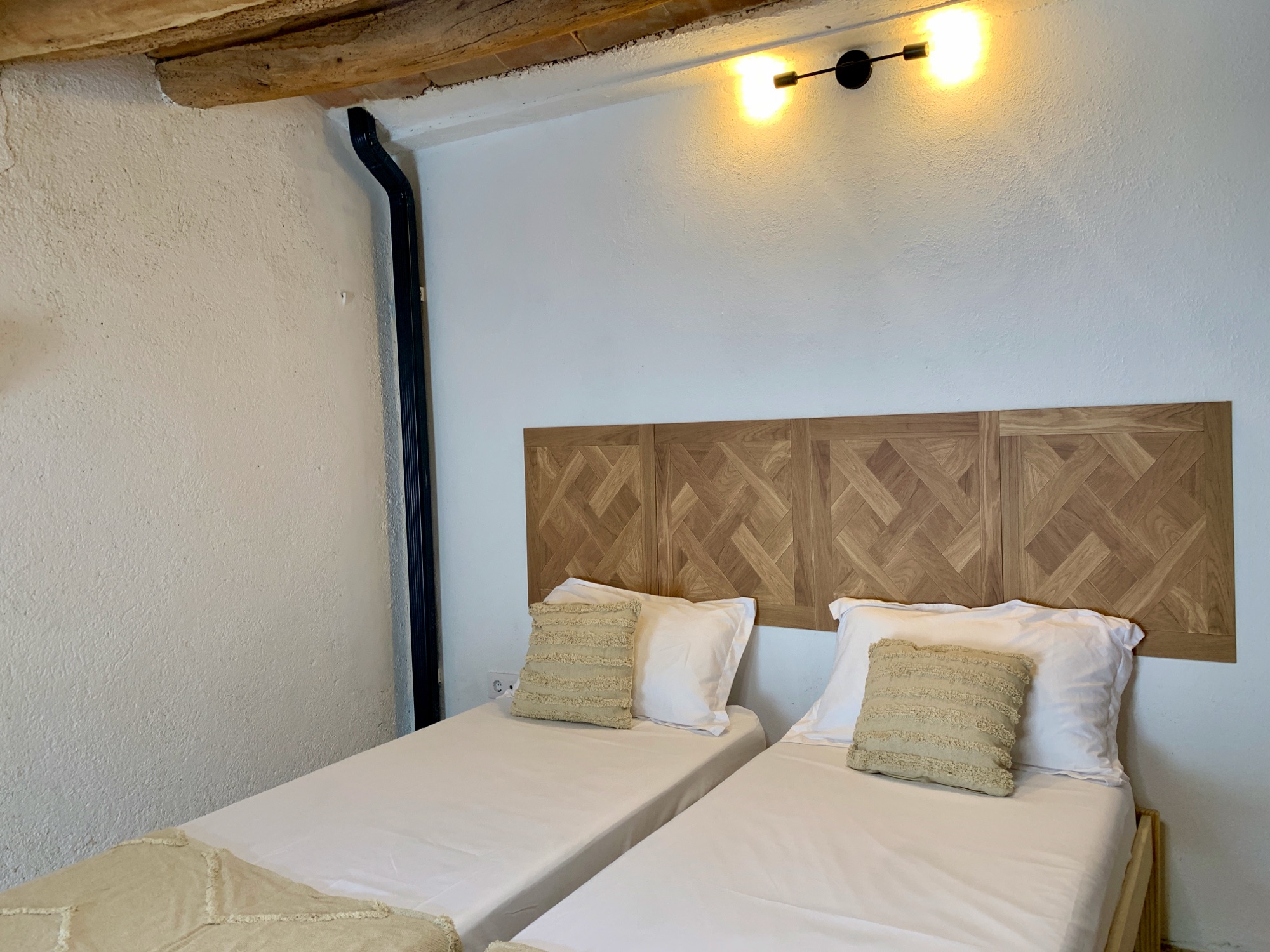 Habitació 4 — capçalera de fusta i tauleta de nit
