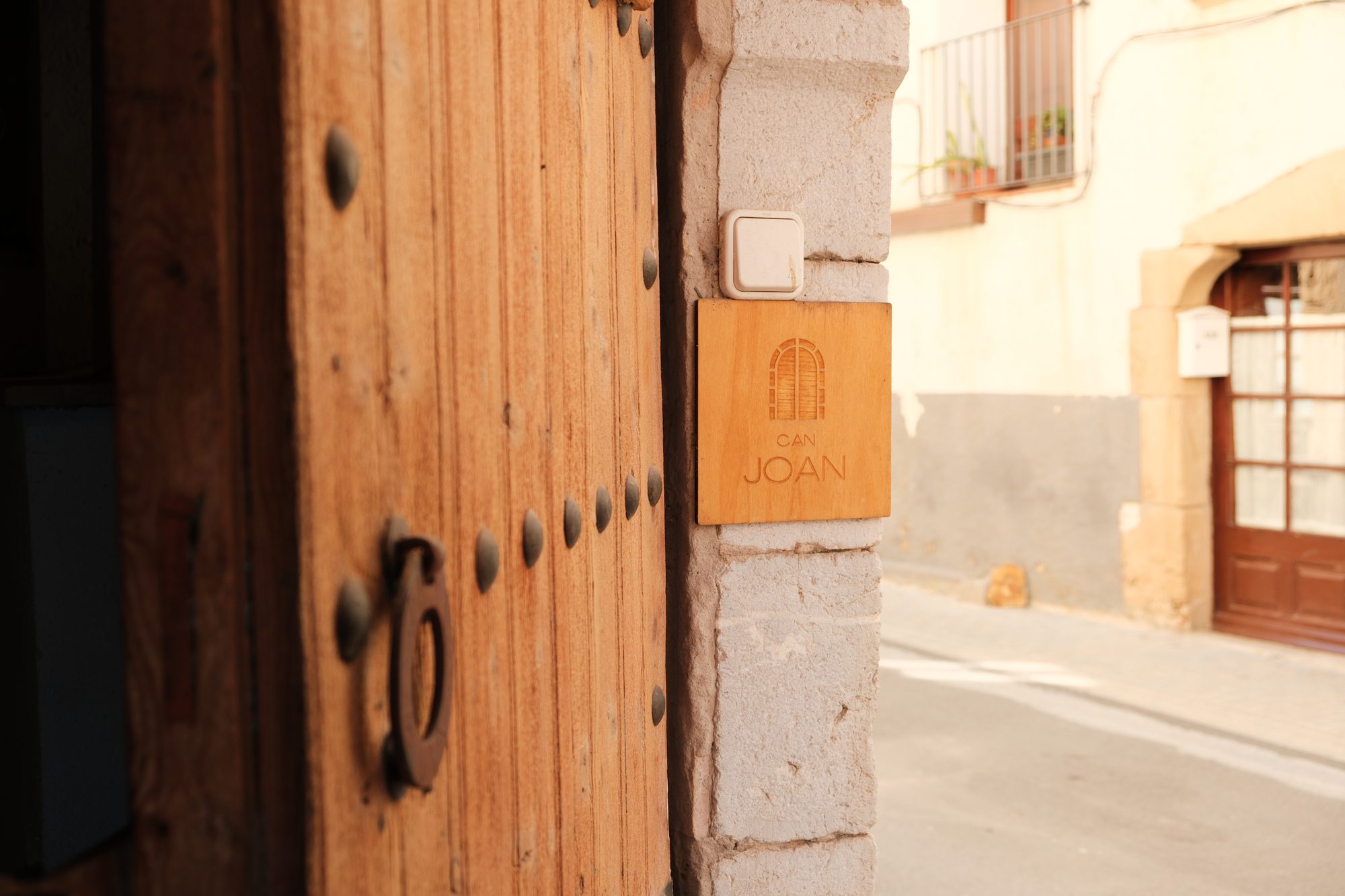 Placa amb el logotip de Can Joan Empordà a la pedra de la portalada